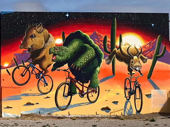Mural by Joe Pagac - tortoise, Jackalope, and Javalina riding bicycles 