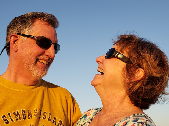 Laughing retired couple outside with sunglasses